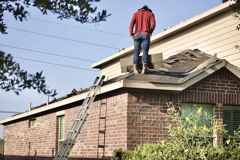 Professional roofer working on a residential roof in Grayson Valley